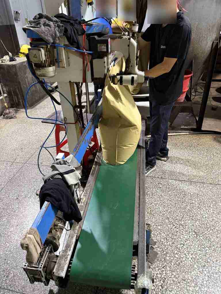 Bag sewing machine and conveyor on the lignosulfonate packing line