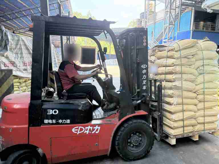 Forklift moving a pallet of bagged lignosulfonate