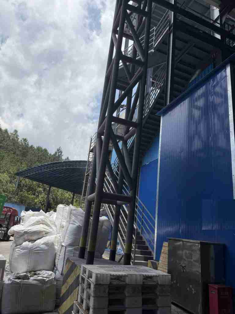 Tower stairway and jumbo bags beside the drying building